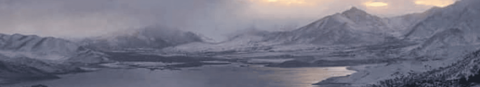 Snow-covered mountains surrounding a calm lake under a cloudy sky.