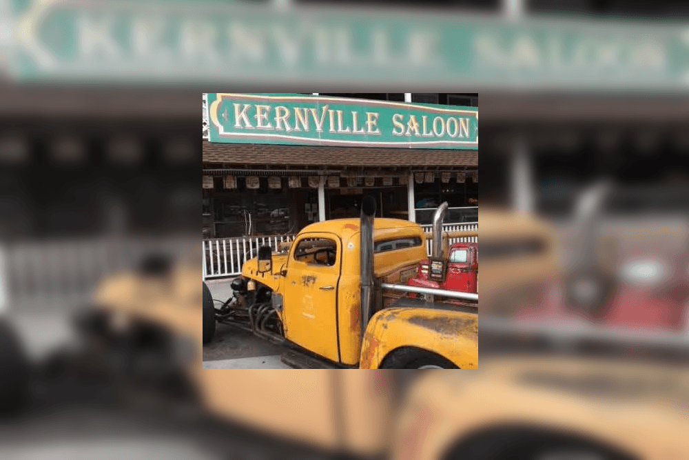 A rusty yellow truck is parked in front of the Kernville Saloon.
